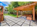 Serene backyard with a stone-tiled patio, a wooden pergola and built-in benches surrounding a fire pit at 496 Rankin Ne St, Atlanta, GA 30308