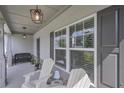 Inviting front porch with a seating area, ambient lighting, and stone accents at 110 Serendipity Way, Dallas, GA 30157