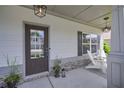Inviting front porch with stone accents, seating area, and ambient lighting at 110 Serendipity Way, Dallas, GA 30157