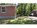 Exterior side of the brick home with a window and a glimpse of the backyard at 2545 Saint Patrick Se St, Atlanta, GA 30317