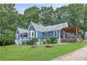 Landscaped home with covered deck provides a serene setting for relaxation and outdoor enjoyment at 4002 Joshua Ln, Douglasville, GA 30135