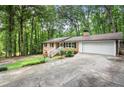 Beautiful brick home with an attached garage and a long driveway, surrounded by lush trees at 505 Samaritan Dr, Cumming, GA 30040