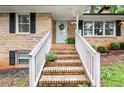 Inviting brick stairway leading up to a front door framed with sidelights, complemented by manicured landscaping at 505 Samaritan Dr, Cumming, GA 30040
