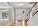 Bright foyer with hardwood floors, staircase, and a view into the front windowed living room at 1350 Rivershyre Pkwy, Lawrenceville, GA 30043