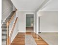 Inviting entryway with hardwood floors, staircase, neutral walls and carpeted living area at 1350 Rivershyre Pkwy, Lawrenceville, GA 30043