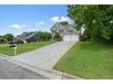 Traditional two-story home with a long driveway leading to a two-car garage, surrounded by a green lawn at 3635 Bardfield Ct, Cumming, GA 30041