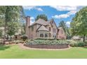 Well-maintained two-story brick home featuring a lush green lawn and mature trees at 1720 Monarch Ct, Cumming, GA 30041