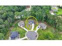 Aerial view of a home nestled in a lush, wooded neighborhood with mature trees and circular driveways at 4056 Friendship Creek Dr, Buford, GA 30519