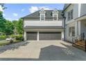 Large two-car garage with dark wooden doors and bright exterior lighting fixtures at 745 Glengate Pl, Atlanta, GA 30328