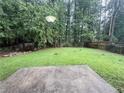 Lush backyard with mature trees and green grass, ideal for outdoor activities and relaxation at 1081 Forest Path, Stone Mountain, GA 30088