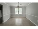 Spacious dining room featuring neutral tones, tile flooring, and classic chandelier lighting at 1081 Forest Path, Stone Mountain, GA 30088