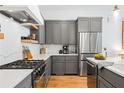Modern kitchen with stainless steel appliances, gray cabinets, quartz countertops, and a gas range at 10904 Serenbe Ln, Chattahoochee Hills, GA 30268