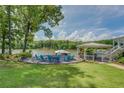 Picturesque backyard features a fire pit with seating and a covered patio overlooking the serene lake at 22 Waters Bridge Cir, Covington, GA 30014