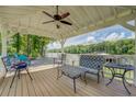Relaxing covered patio has a ceiling fan, dining table, seating, and views of the lake and backyard fire pit at 22 Waters Bridge Cir, Covington, GA 30014