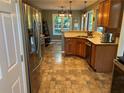 Well-lit kitchen with stainless steel appliances, a double sink, and wood cabinetry at 990 Fountain Glen Dr, Lawrenceville, GA 30043
