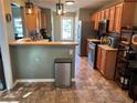 Well-lit kitchen featuring stainless steel appliances and wood cabinetry, with a partial view of an adjacent room at 990 Fountain Glen Dr, Lawrenceville, GA 30043