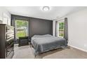 Comfortable bedroom with neutral tones, plush carpet, and two bright windows at 5706 Forest Pl, Acworth, GA 30102