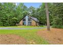 Exterior view of home with unique architecture and a spacious front yard surrounded by mature trees at 1605 Saint Tropez Way, Atlanta, GA 30350
