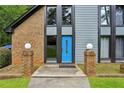 Close up of a home's exterior with a bright blue front door and stylish brick accents at 1605 Saint Tropez Way, Atlanta, GA 30350
