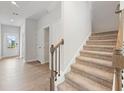 Carpeted staircase with stained wood railing and black iron balusters at 2058 Brookhill Way, Snellville, GA 30078