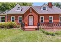 Attractive brick home with dormer windows and a landscaped front yard with a well-manicured lawn at 407 E College E St, Bowdon, GA 30108