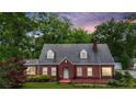 Charming brick home with a well-maintained lawn, mature trees and dormer windows at 407 E College E St, Bowdon, GA 30108