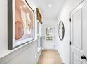 Bright hallway with hardwood floors, modern art, and natural light at 5753 Tillman Way, Powder Springs, GA 30127