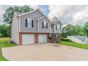Split-level house boasting a two-car garage, neutral siding with brick accents, and a meticulously maintained yard at 725 Signature Trce, Palmetto, GA 30268