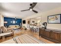 Open-concept living room with wood floors, ceiling fans, and a view into the eat-in kitchen at 107 Bowen Rd, Stockbridge, GA 30281