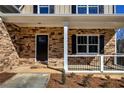 Inviting front porch with stone accents, white columns, and a railing at 30 Grand Georgian Ne Ct, Cartersville, GA 30121