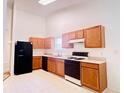 Functional kitchen features wooden cabinets, black appliances, and ample counter space at 6214 Treeridge Nw Dr, Acworth, GA 30101