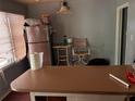 Kitchen area featuring a stainless steel refrigerator, breakfast bar, and casual dining space at 4513 College St, Forest Park, GA 30297