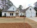 Beautiful exterior of a modern farmhouse-style home with white siding, gabled roof, and a two-car garage at 6149 Pinewood Se Dr, Covington, GA 30014
