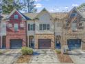 Charming townhome exteriors with one-car garages, brick accents, neutral colors and well-maintained landscaping at 2772 Archway Ln, Brookhaven, GA 30341