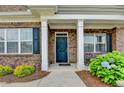Inviting entryway showcasing a blue front door flanked by white columns and manicured landscaping at 3411 Lindenridge Dr, Buford, GA 30519