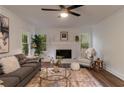 Cozy living room featuring a fireplace, ceiling fan, and large windows for natural light at 607 Hickory Creek Ln, Woodstock, GA 30188