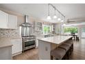 Modern kitchen with stainless steel appliances, a central island with seating, and bright natural light from the windows at 1104 Fox Ln, Woodstock, GA 30188