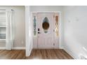 Bright foyer with decorative glass door, wood flooring, and white shiplap accent wall at 1139 Shiloh Nw Ln, Kennesaw, GA 30144