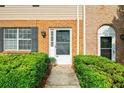 Close-up of townhome entrance featuring brick and siding, black shutters, and manicured landscaping at 406 Northdale Ct, Lawrenceville, GA 30046