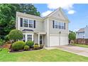 Well-maintained two-story home with a manicured lawn, garden beds, and a two-car garage at 585 Ashland Pkwy, Woodstock, GA 30189