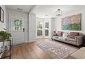 Bright living room with natural light, hardwood floors, a comfortable sofa, and a bay window at 585 Ashland Pkwy, Woodstock, GA 30189