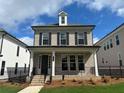 Charming two-story home featuring a brick facade, black shutters, and a welcoming front porch at 163 Basil St, Cumming, GA 30040