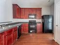 Functional kitchen features dark appliances, wood cabinets, and hardwood floors at 4217 High Park Ln, Atlanta, GA 30344