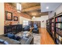 Open-concept living room with hardwood floors, exposed brick wall, and library bookshelves offers space to relax and enjoy a good book at 1026 Saint Charles Ne Ave # 15, Atlanta, GA 30306