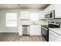 Modern kitchen boasting white cabinets, stainless steel appliances, and a window at 6481 Alford Way, Lithonia, GA 30058