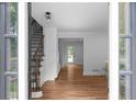 Bright entryway featuring hardwood floors, staircase with iron railings, and views of the front yard at 7110 Northgreen Dr, Atlanta, GA 30328