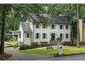 View of the beautiful two-story home with a well-manicured lawn, complemented by mature trees and lush greenery at 7110 Northgreen Dr, Atlanta, GA 30328