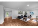 Open living room featuring hardwood floors, neutral-toned furniture, recessed lighting, and stylish decor at 7110 Northgreen Dr, Atlanta, GA 30328
