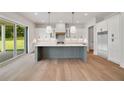 Bright, open kitchen with a large island, stainless steel appliances, and sliding glass doors to the backyard at 133 Daxton Dr, Canton, GA 30115