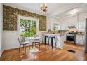 Cozy eat-in kitchen with wood floors, white cabinets, stainless steel appliances, and eye-catching wallpaper at 615 Sycamore Dr, Decatur, GA 30030